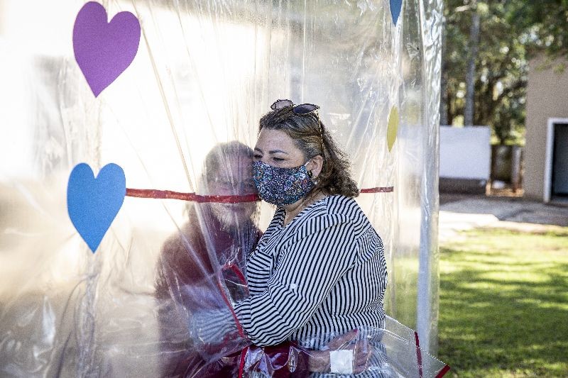 A daughter hugs his mother at the Geriatric Clinic Tr Figueiras on June 16, 2020 in Gravatai, Brazil. The clinic created the Tunel do Abraco (hug tunnel) for elderly residents to be able to hug relatives after more than 70 days apart due to the coronavirus pandemic. The tunnel is made of a thick plastic curtain with sleeves, which guarantees the safety of families. After each use, the environment is cleaned by a clinic professional. (Photo by Lucas Uebel/Getty Images)